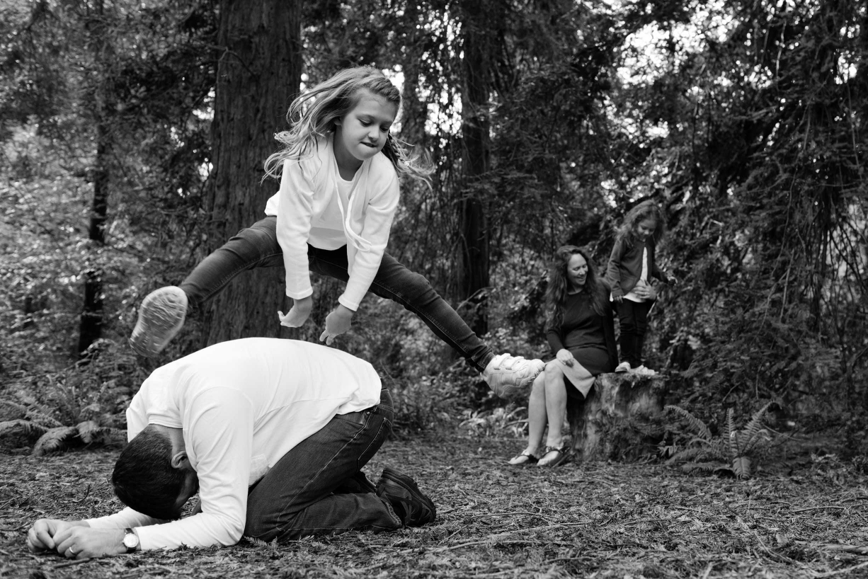 Playing leapfrog during a fun family portrait session in Kew, London.