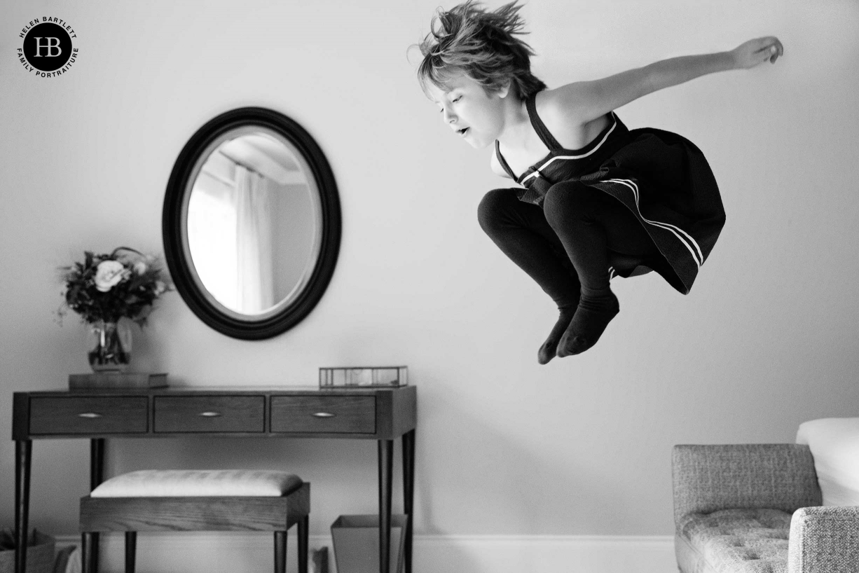 A girl jumps into the air during a shoot by London photographer Helen Bartlett which involved newborn and sibling photography