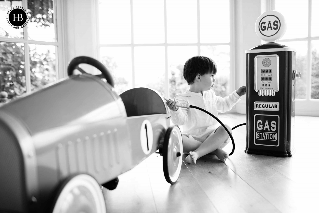 A boy plays with his toy car during a family photoshoot in his home