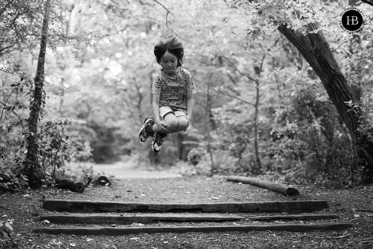 Boy caught mid-air as he jumps with his legs tucked up. Image used to show amazing tracking focus of Canon EOS R5 at wide apertures.