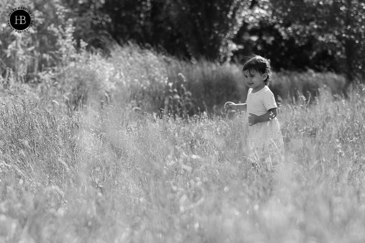 Girl walks through long grass. Image is backlit and shows the way Canon EOS R5 picks out detail in the grass and also focuses at very wide apertures.