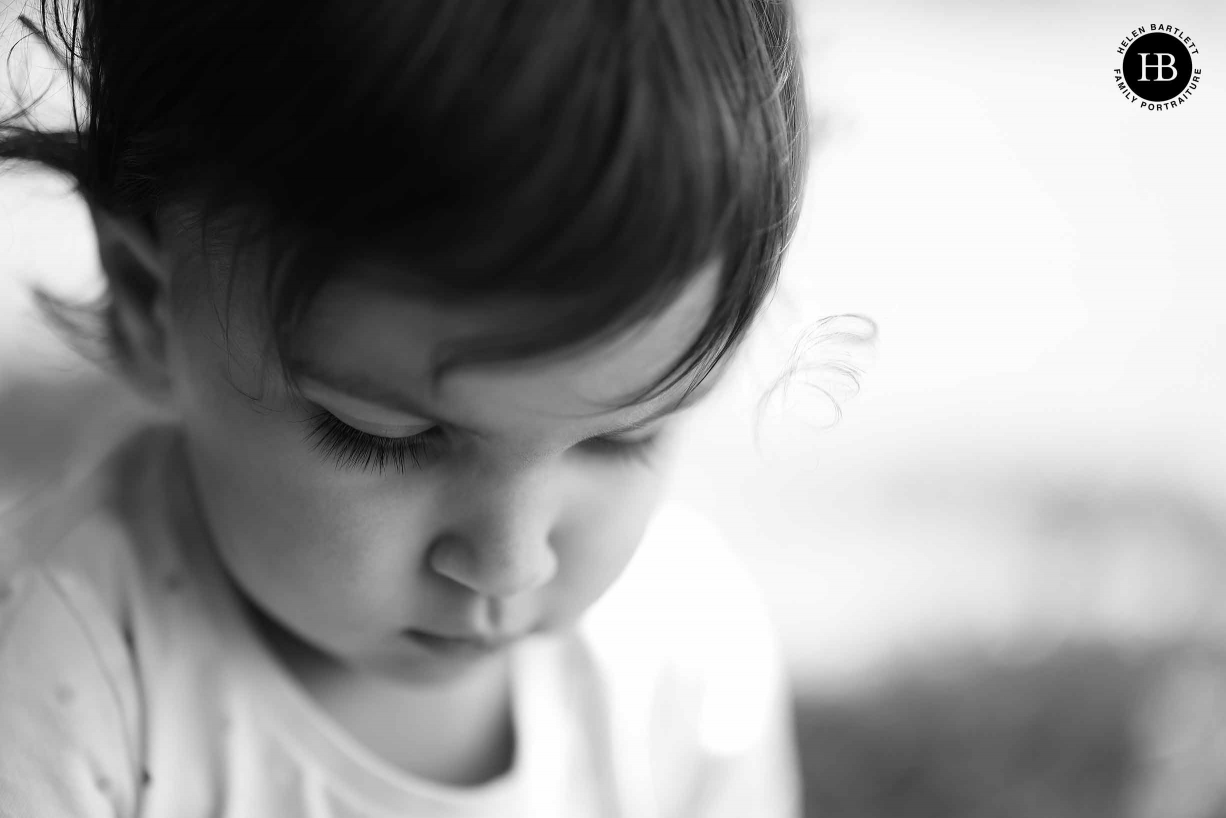 Portrait headshot of little girl with shallow depth of field to emphasis eyelashes and a beautiful curl by her face.