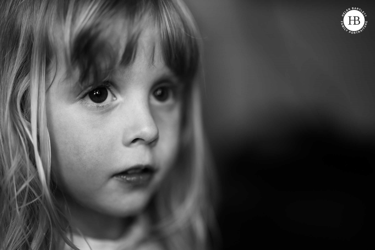 Window lit, head and shoulders, portrait of little girl in black and white.