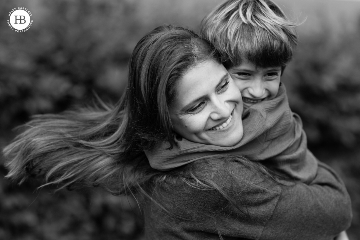 mum and son hug wearing plain coloured tops