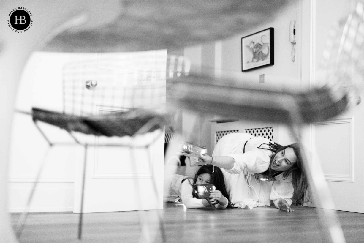 mum and daughter play laser tag during family photo shoot in parsons green sw6