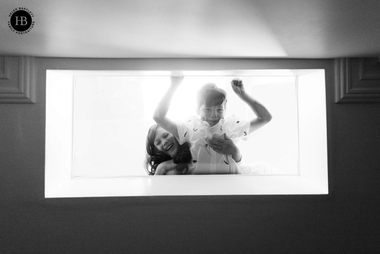 children look down through skylight into basement room