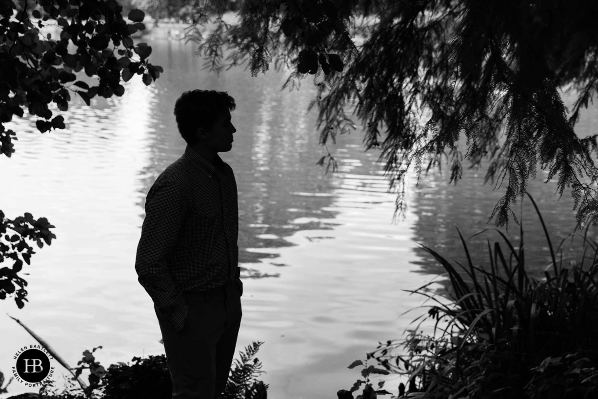 silhouette of teenage boy by the lake at kew