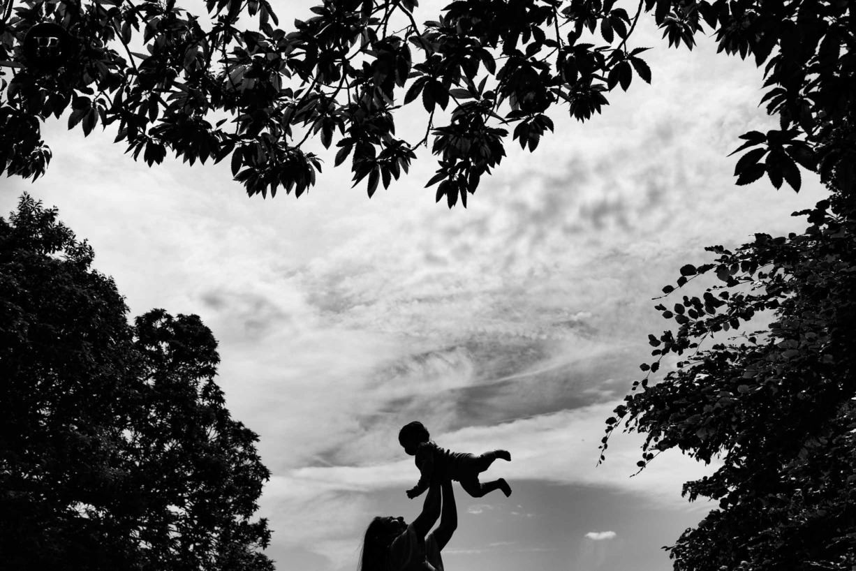 Silhouette of mum holding baby in the air in paddington