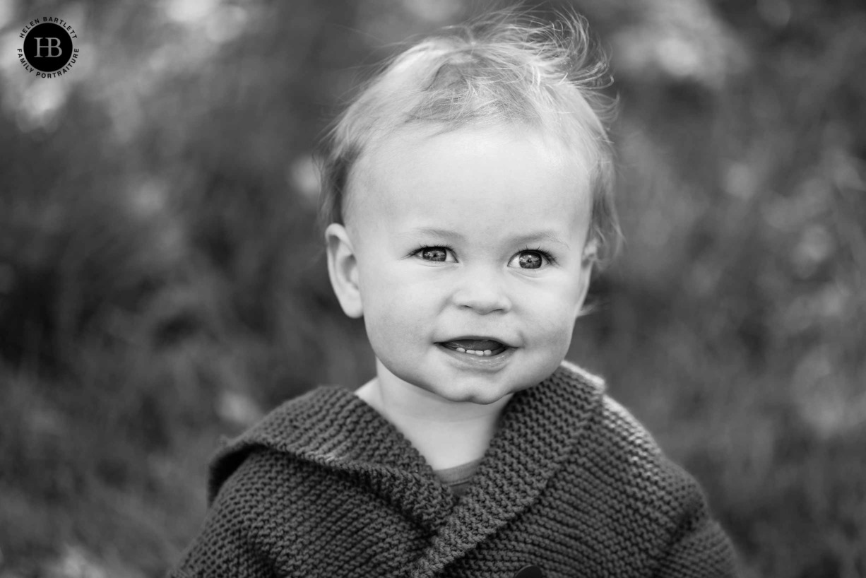 Head and shoulders portrait of baby in black and white on Ealing Common