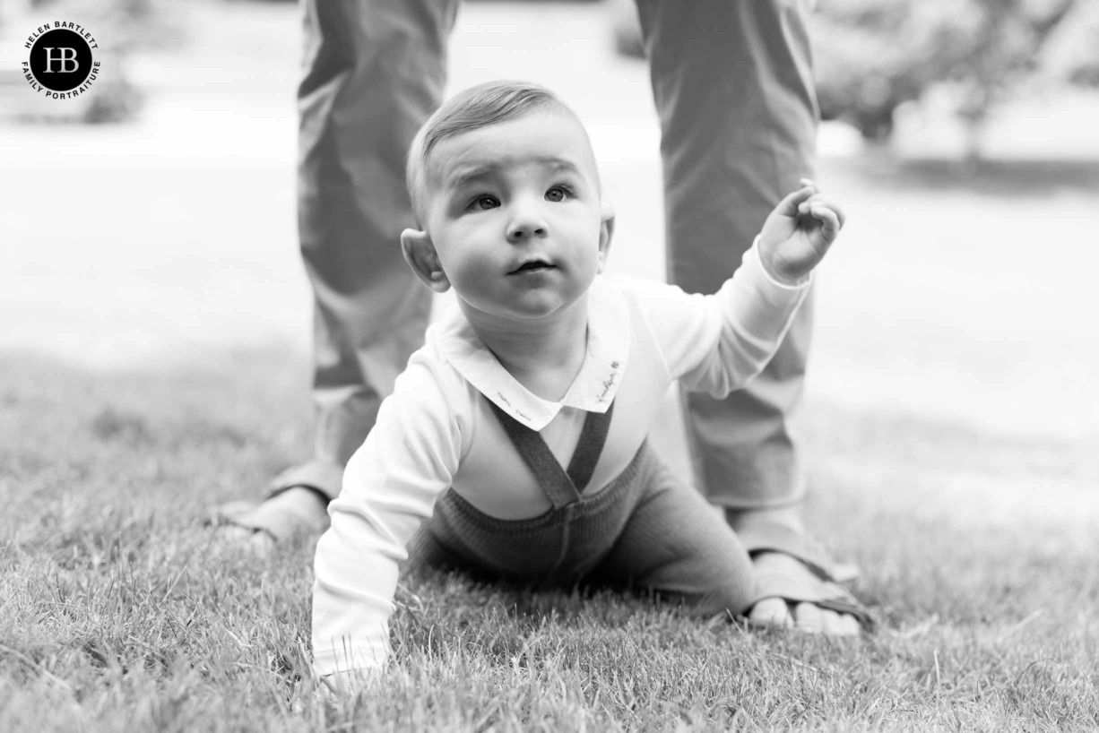 nine month old baby crawling between dads legs