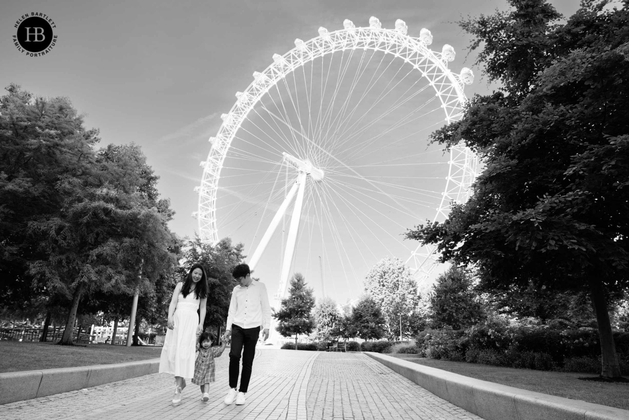 family walk down the path by the London eye on a London landmarks photo shoot