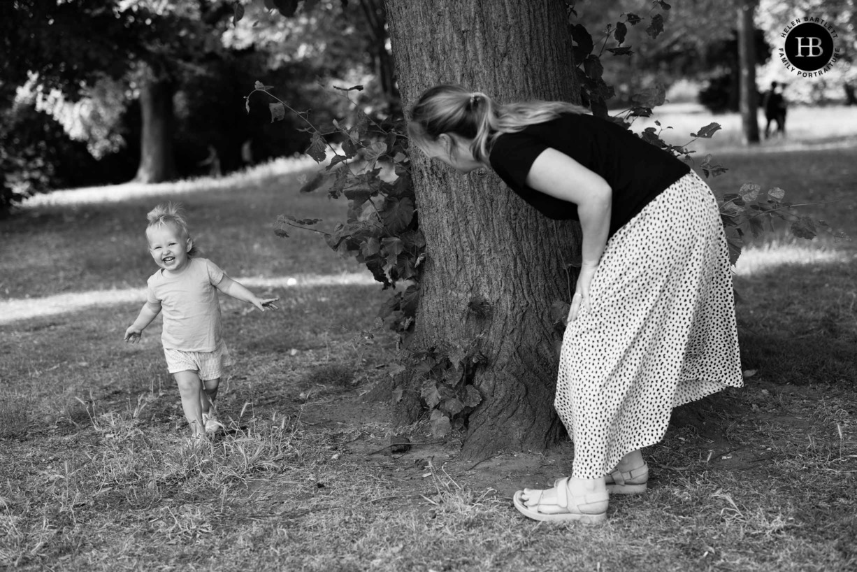 mum and toddler play peek-a-boo in hackney park