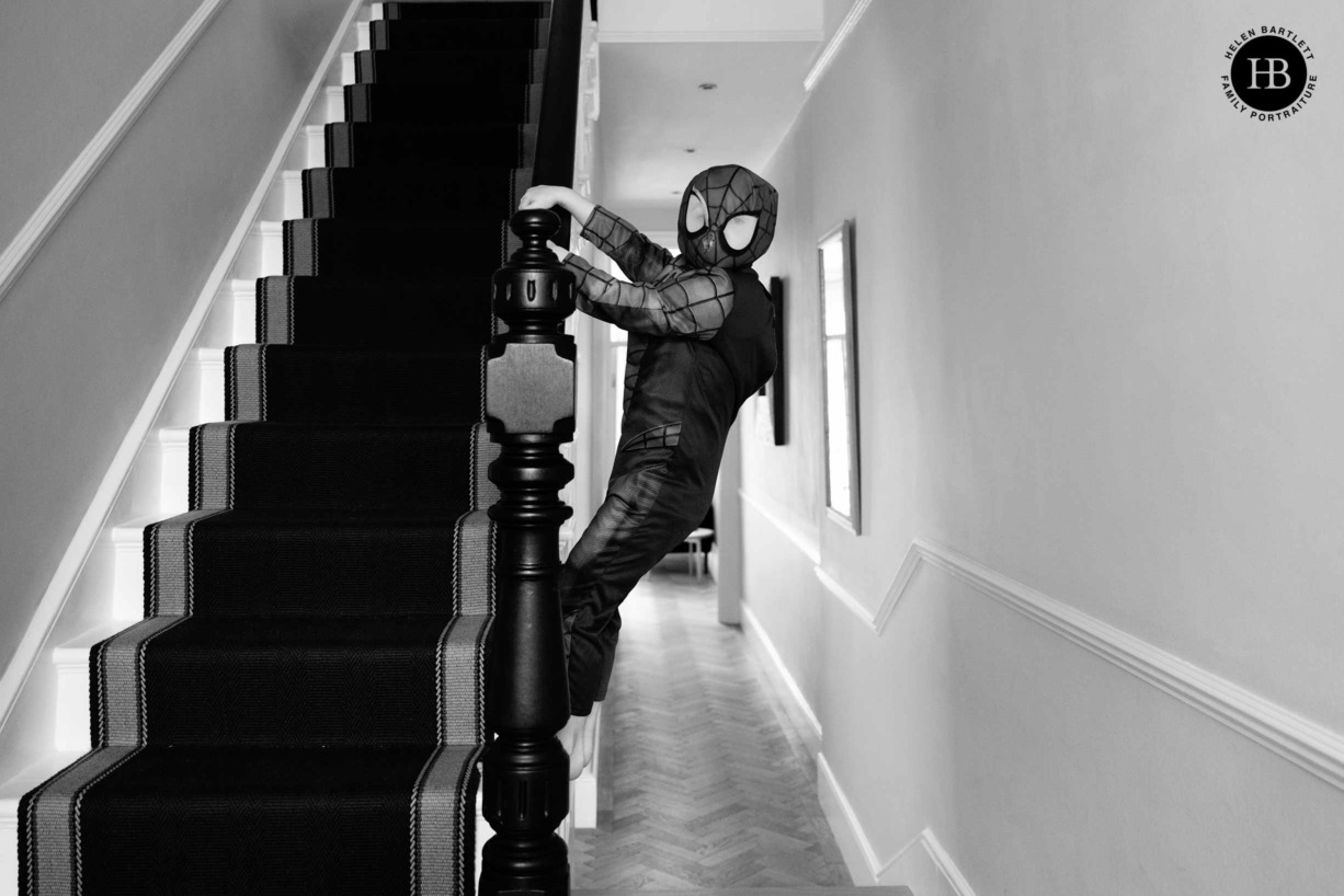 boy-dressed-as-spiderman-climbs-bannisters