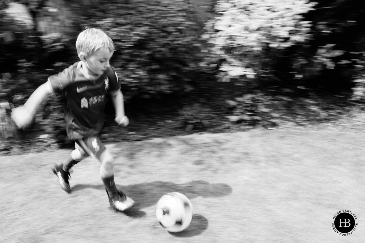 panning-technique-used-to-photograph-boy-playing-football-in-his-garden