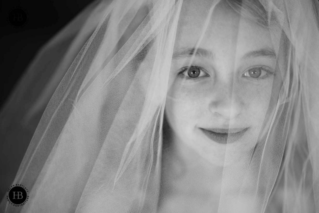 little-girl-tries-on-mothers-wedding-dress-as-part-of-family-photo-shoot-in-winchmore-hill