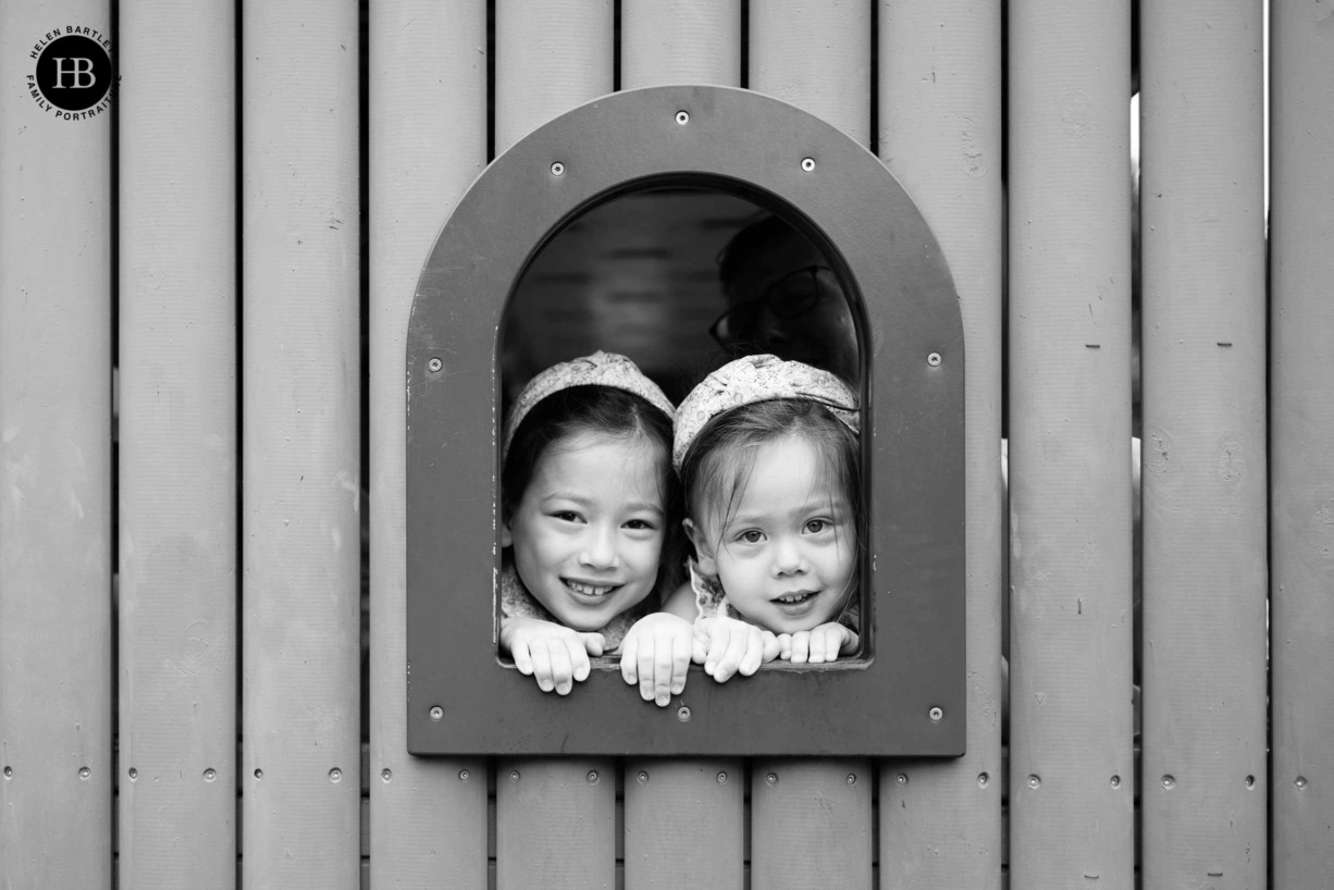 children-peek-through-window-in-climbing-frame