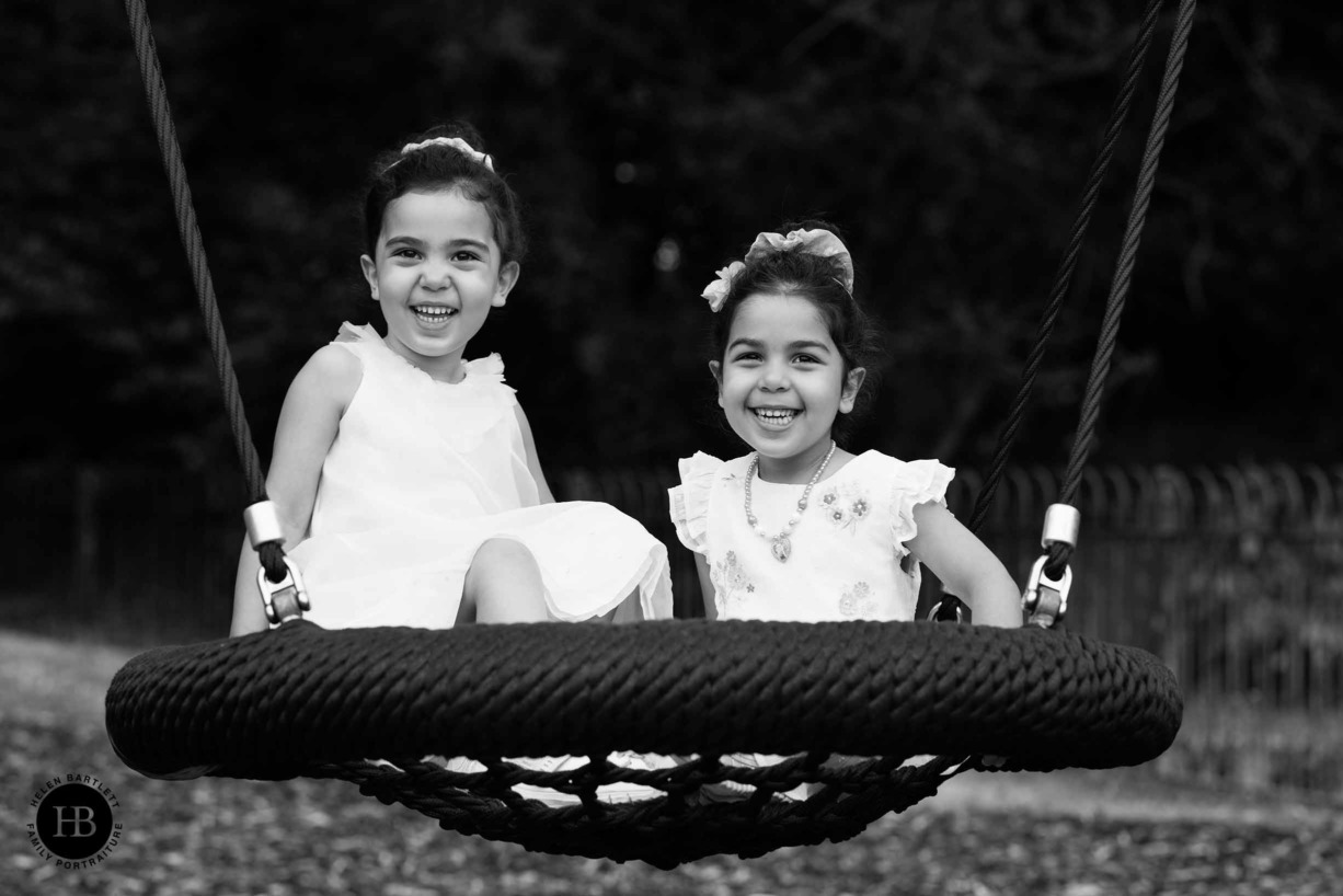 two-little-girls-laughing-on-swing-monochrome