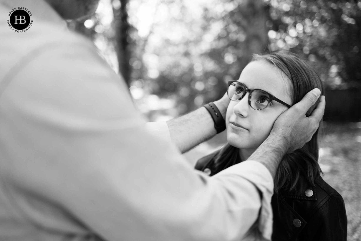 girl-looks-at-father-as-he-holds-her-face-in-his-hands