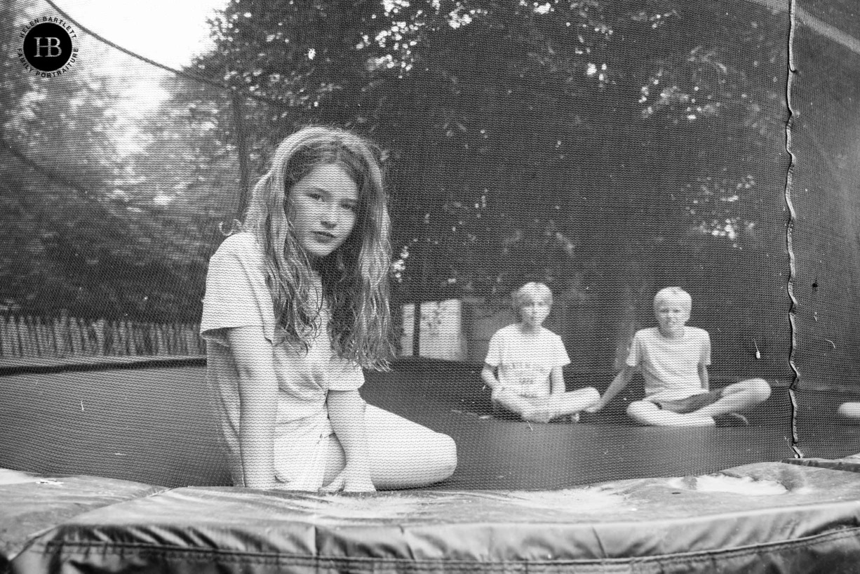 portrait-girl-looking-through-trampoline-safety-net