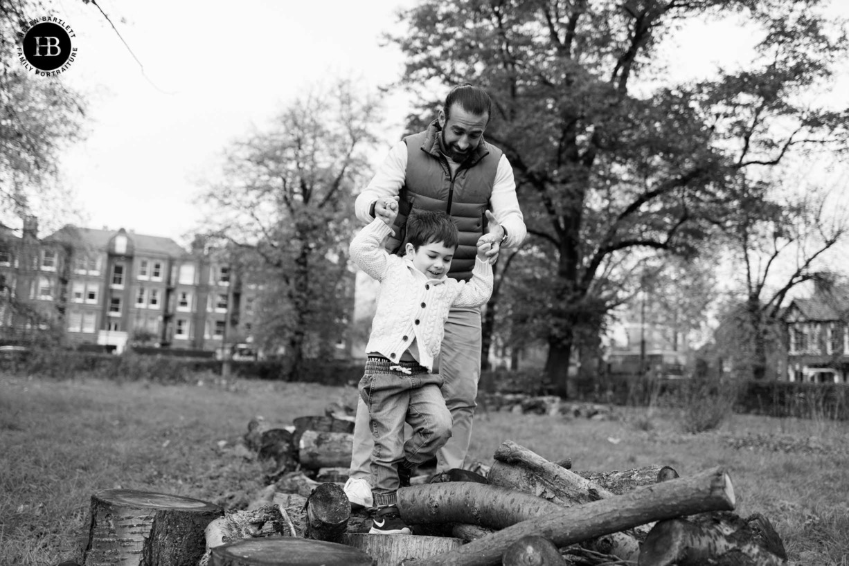 dad-helps-boy-balance-logs-acton