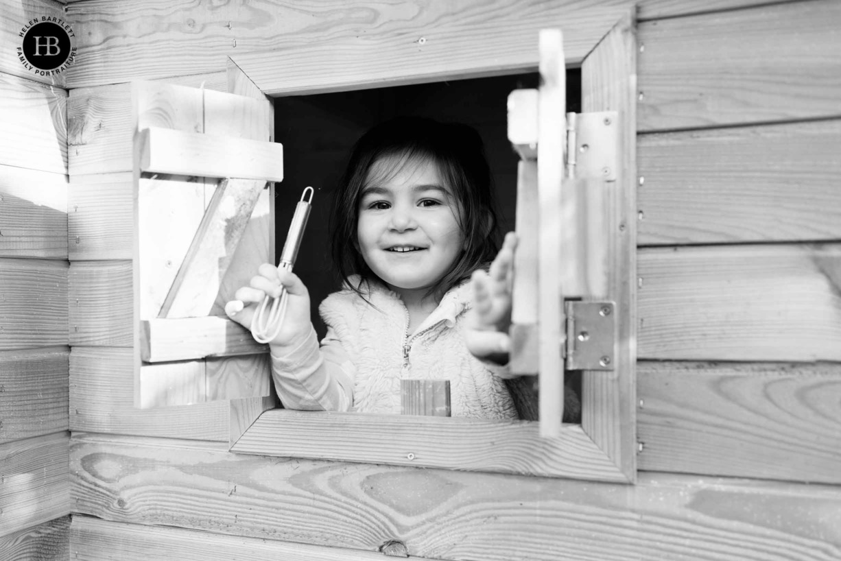 little-girl-looks-out-of-playhouse-window