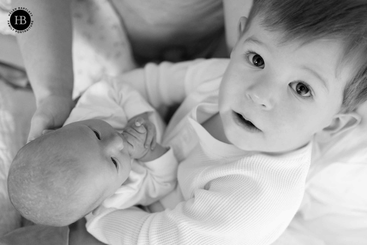 toddler-holds-baby-sister-looks-at-camera