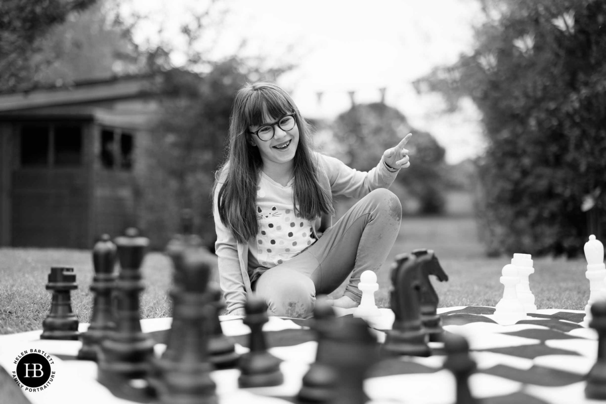 little-girl-plays-garden-chess-family-photo-shoot-esher