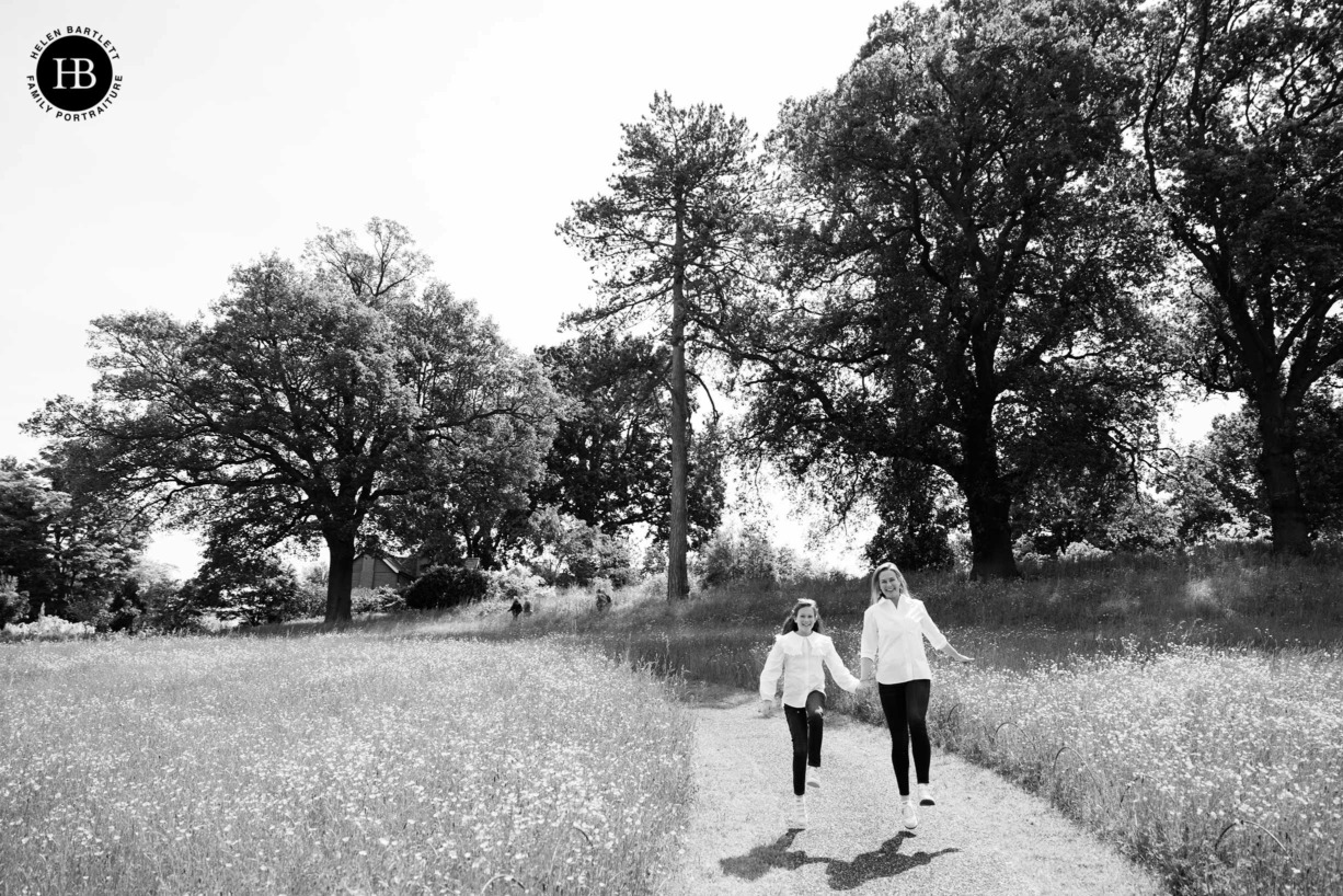 girl-and-mum-skip-down-hill-wisley-surrey-professional-photo-shoot