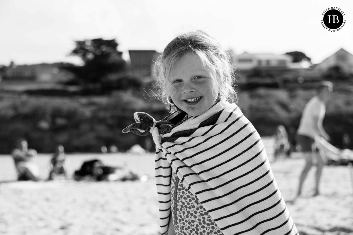 child-covered-in-sand-wearing-towel-cape-on-the-beach