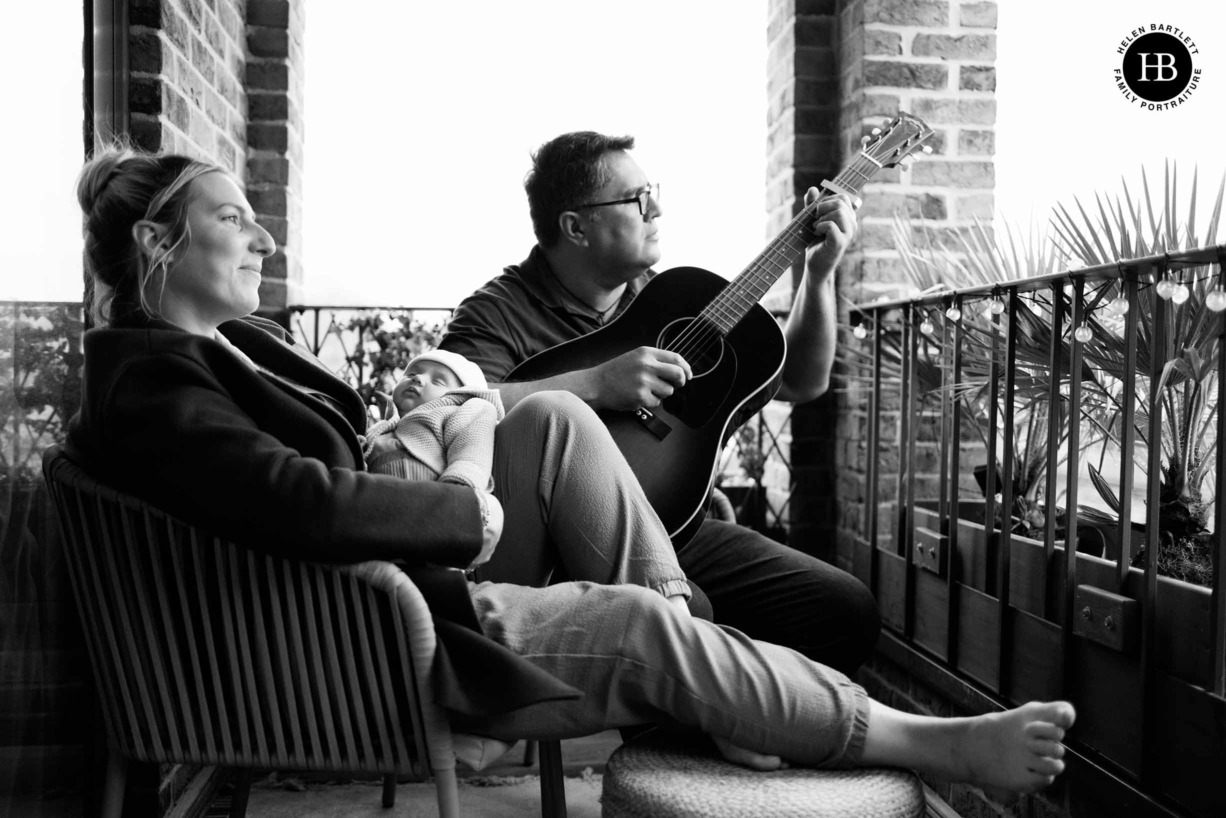 family-on-balcony-with-newborn-father-play-guitar-east-london-photo-shoot