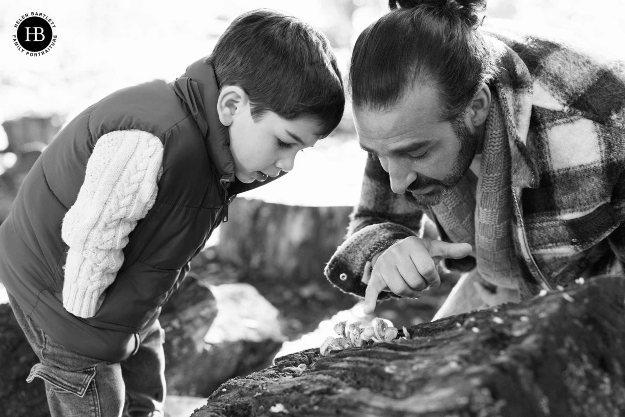 father-and-son-look-at-mushrooms-growing-on-log