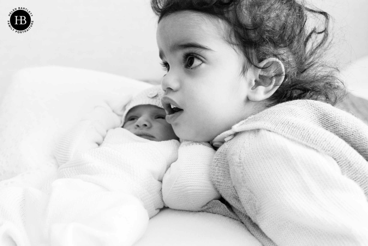 toddler-snuggles-with-newborn-sibling